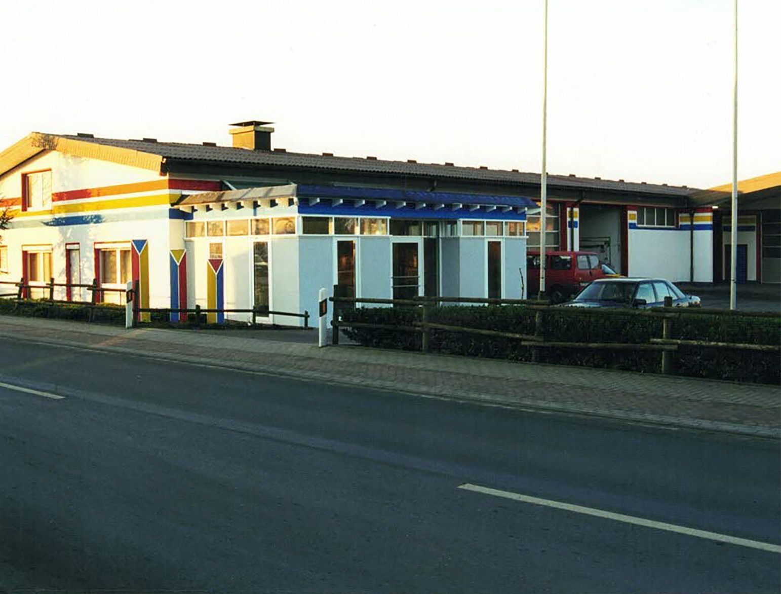 Anbau der Ausstellung Ein rotes Auto steht vor einem Gebäude am Straßenrand