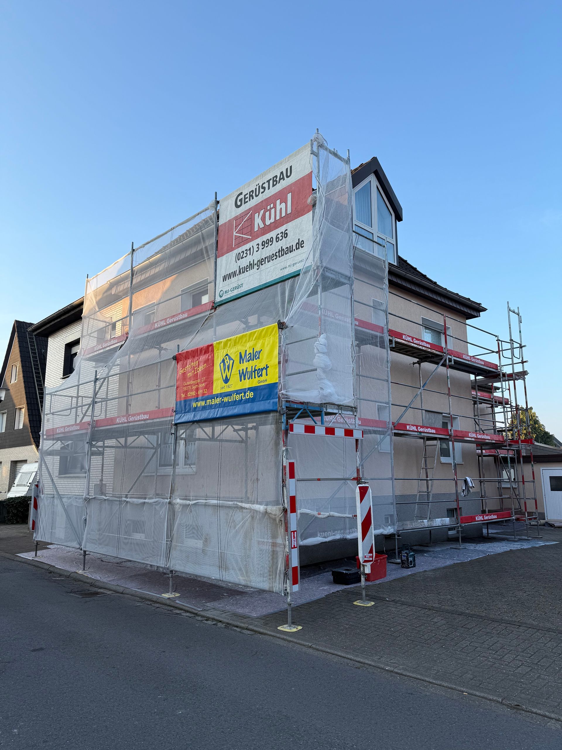 Eine blaue Säule in einem Flur neben einer gelben Tür.