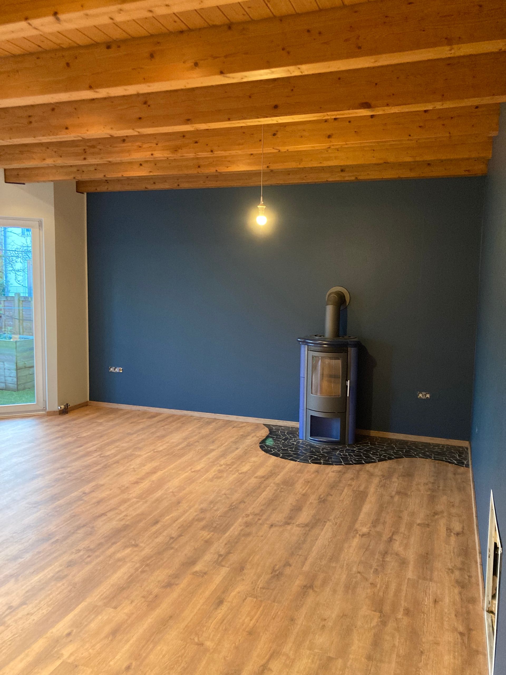 Ein Mann hält einen Pinsel in der Hand, während er eine Wand streicht.