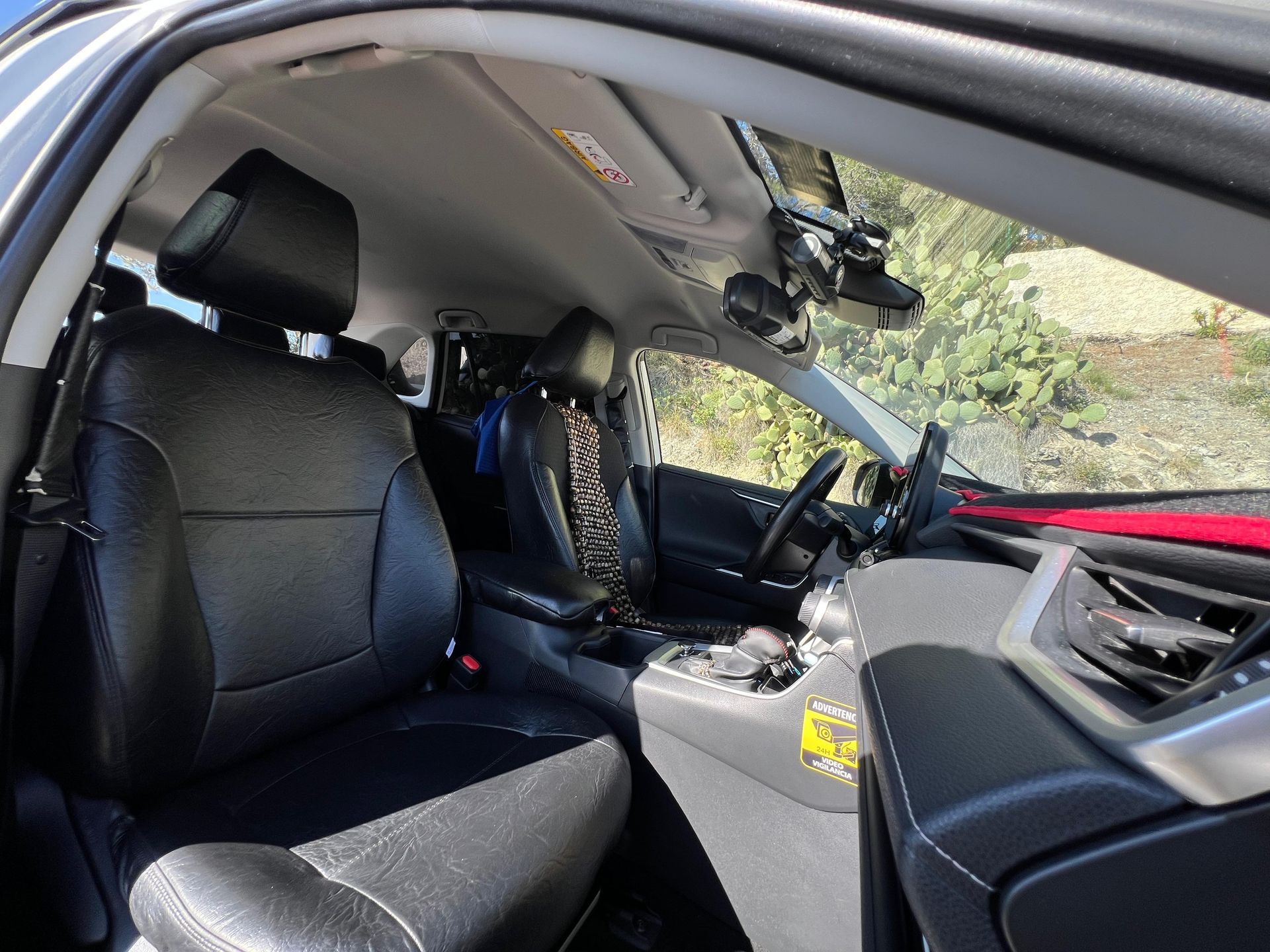 El interior de un coche con asientos de cuero negro.