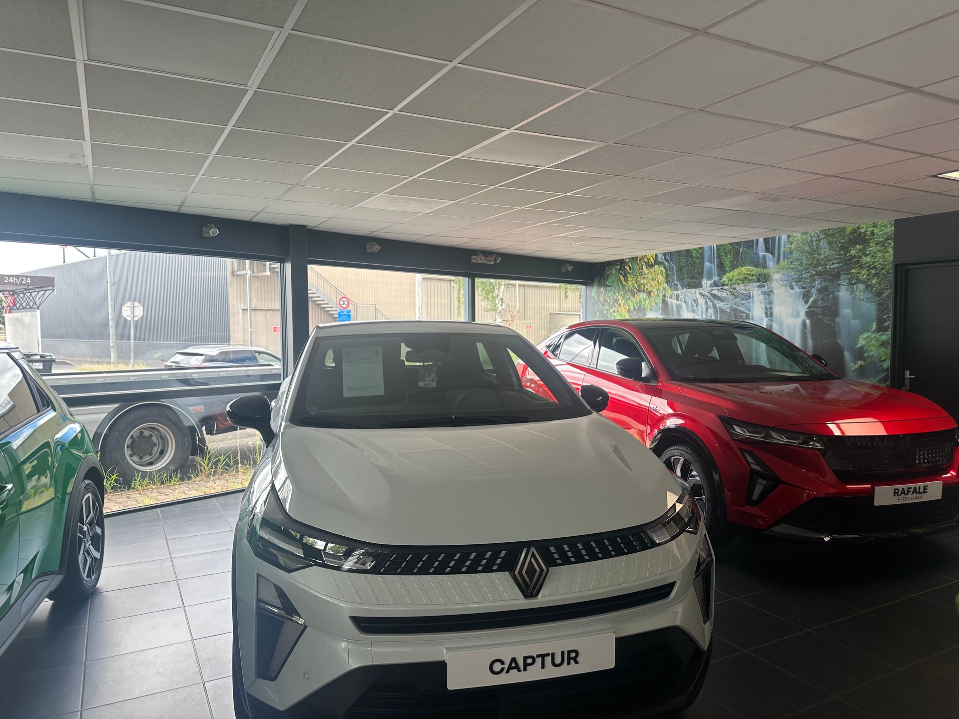 Des voitures blanches et rouges à l'intérieur d'un showroom ; la voiture blanche est à l'avant.