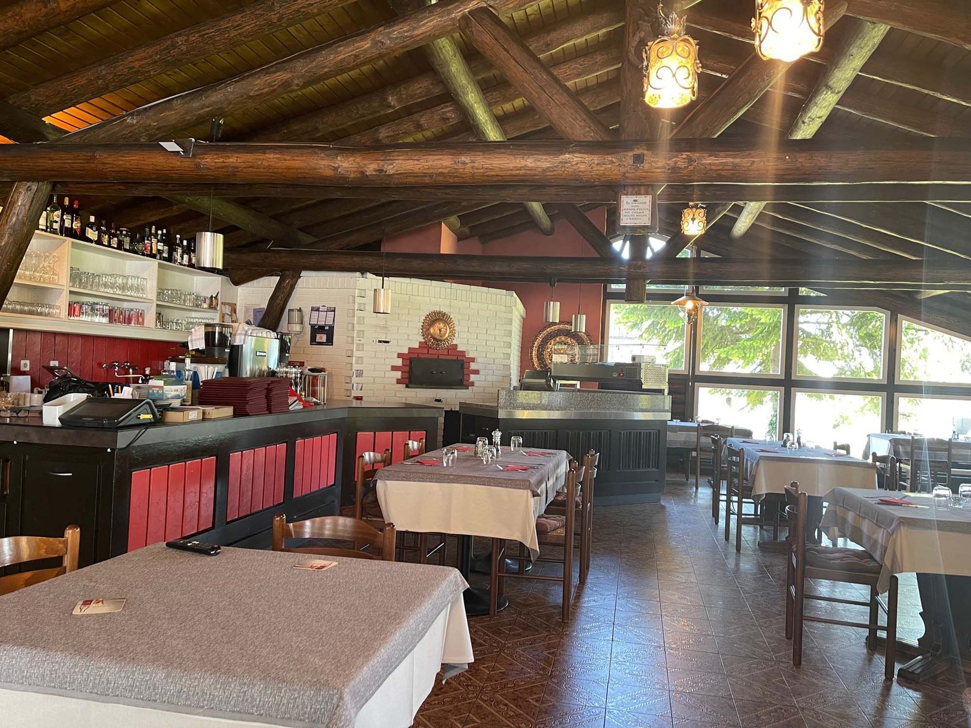 Ein Restaurant mit Tischen und Stühlen und einer Holzdecke