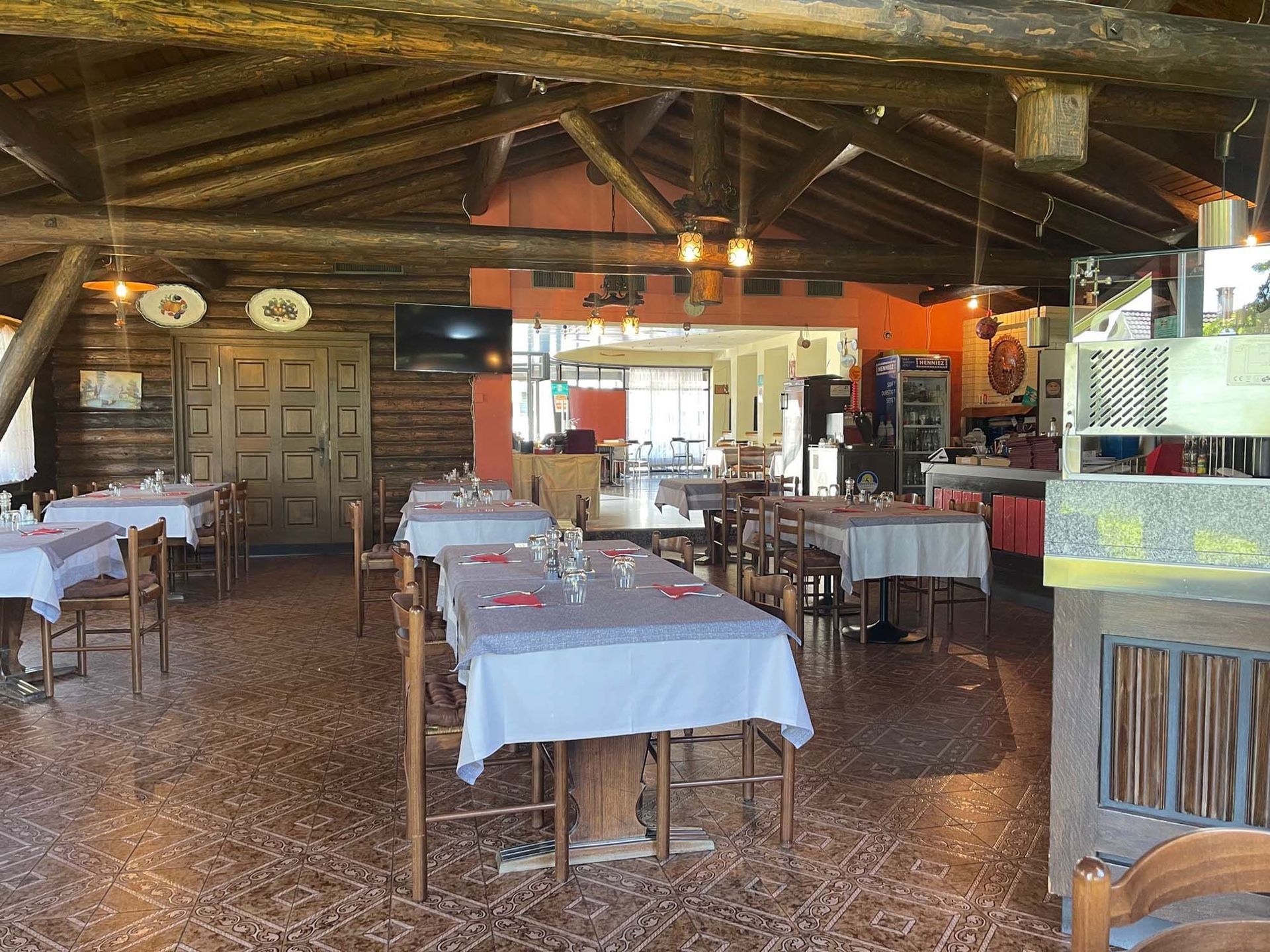 Ein Restaurant mit Tischen und Stühlen und einer Holzdecke