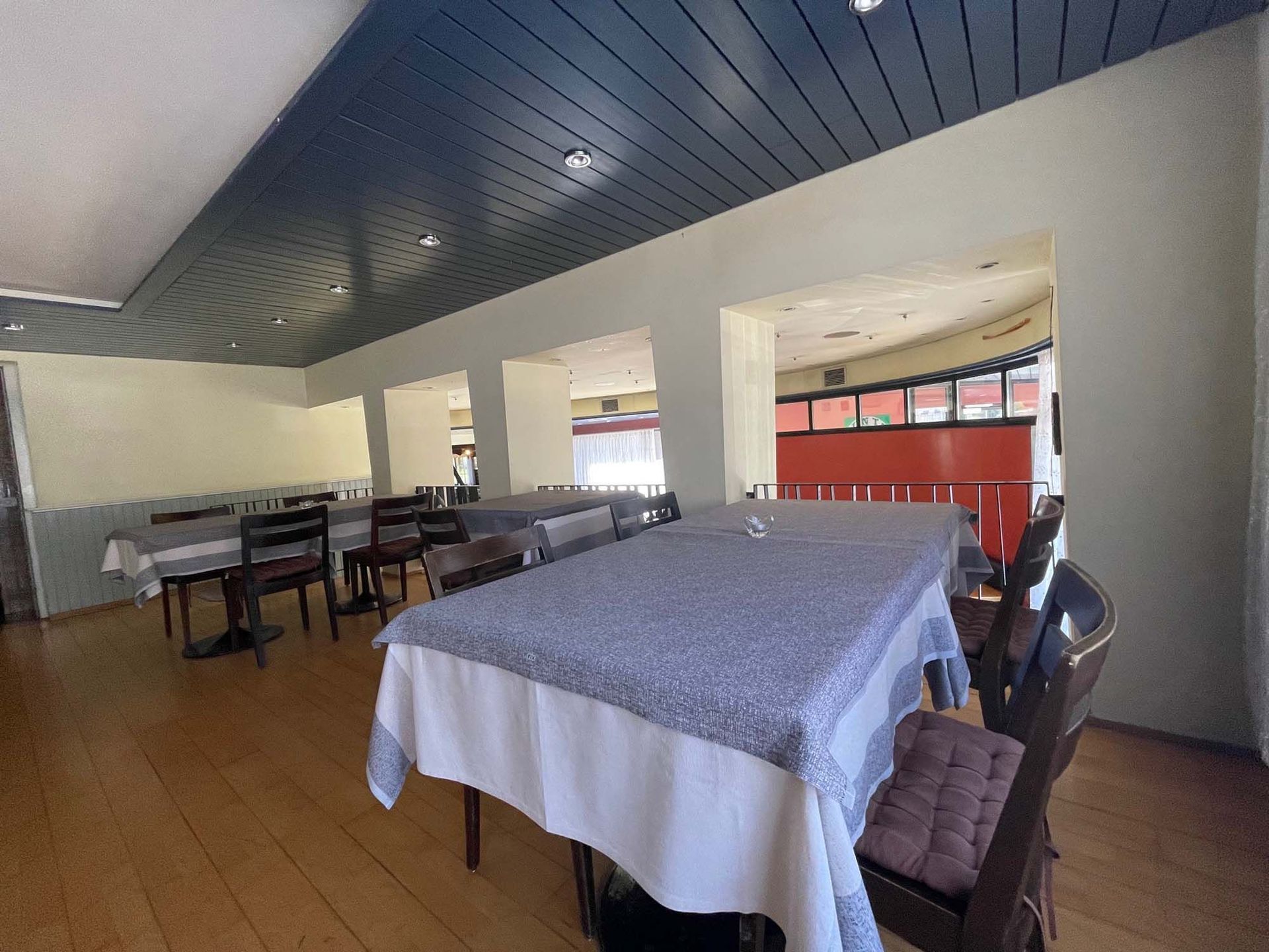 Ein Restaurant mit Tischen und Stühlen und einer blauen Decke