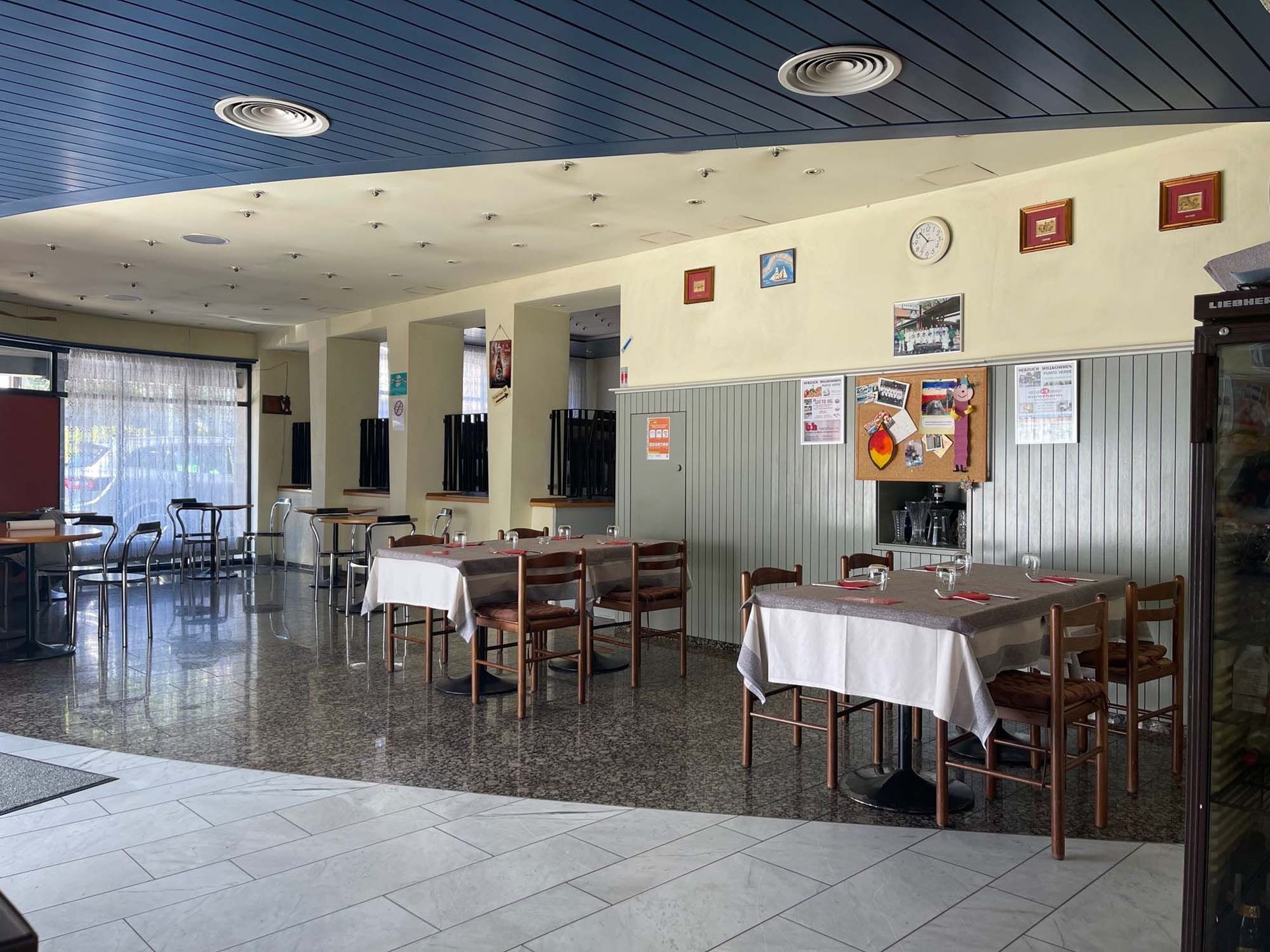 Ein Restaurant mit Tischen und Stühlen und einer Uhr an der Wand