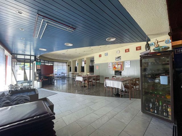 Ein großer Raum mit Tischen und Stühlen und einer blauen Decke