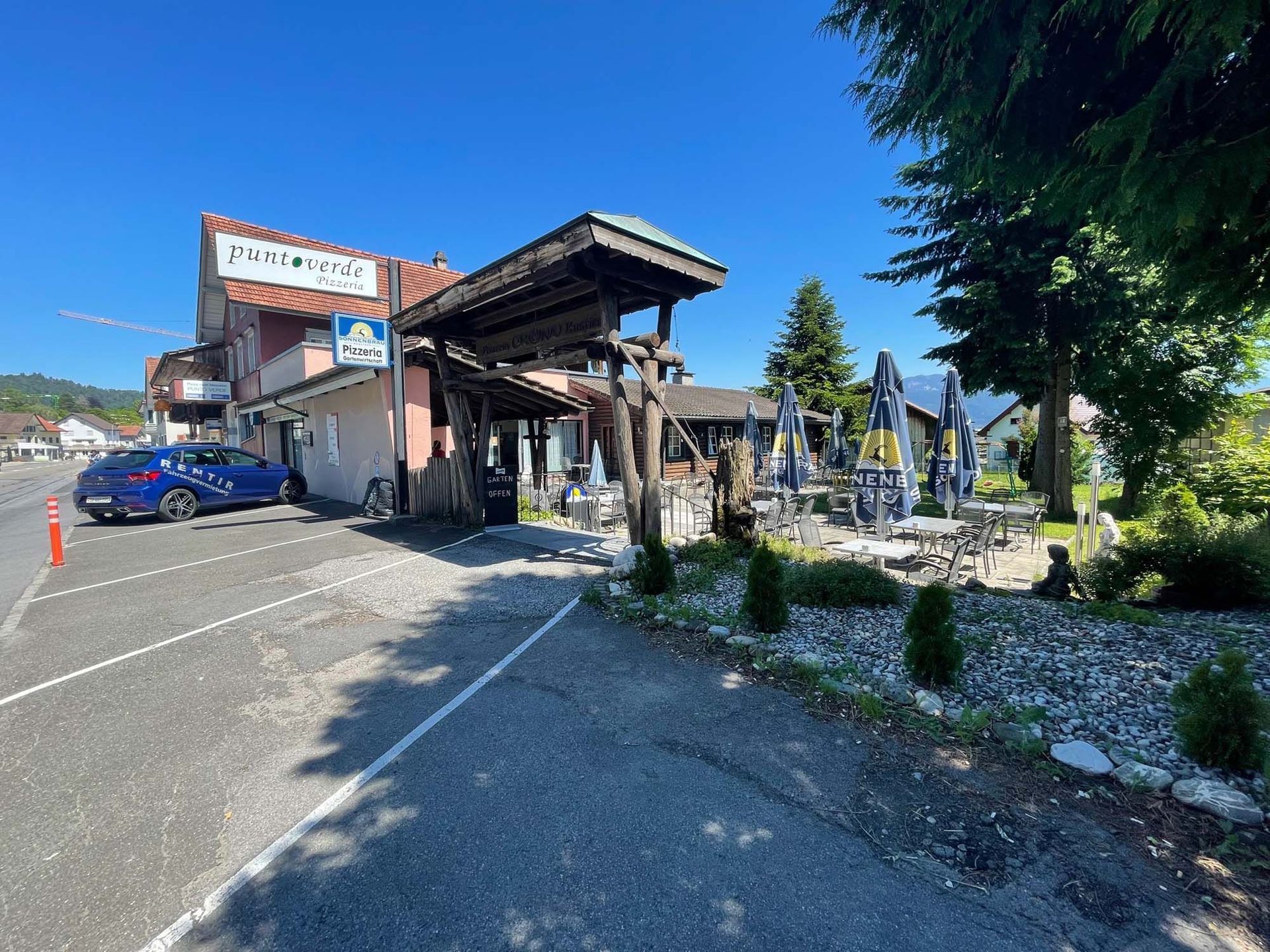 Ein Auto ist vor einem Gebäude neben einer Straße geparkt.