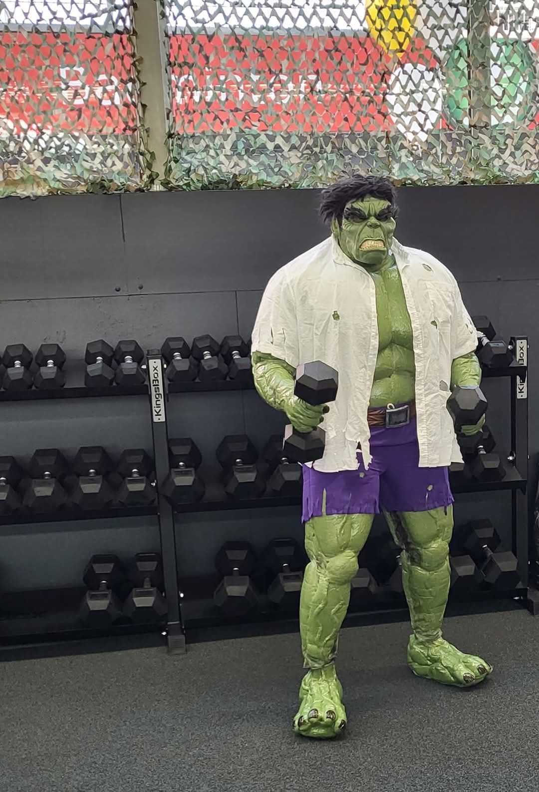 Hulk Cosplay Figur im Fitnessstudio Beim Hanteltraining