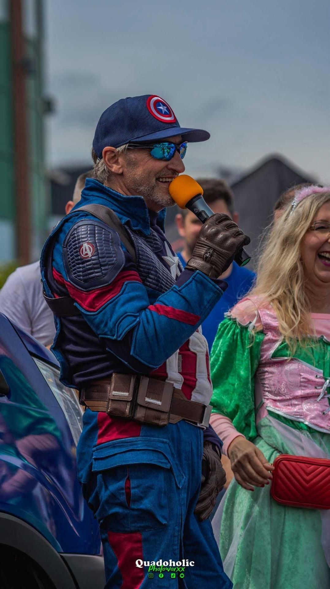 Ein Mann im Captain America-Kostüm hält ein Mikrofon.