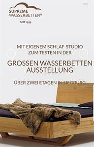 Ein Holzbett mit einer Decke darauf.