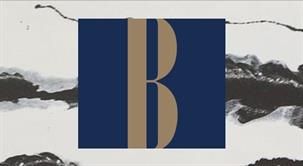 Auf weißem Hintergrund steht ein blau-goldener Buchstabe B.