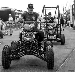 Auf einem Schwarzweißfoto fährt ein Mann ein Quad.