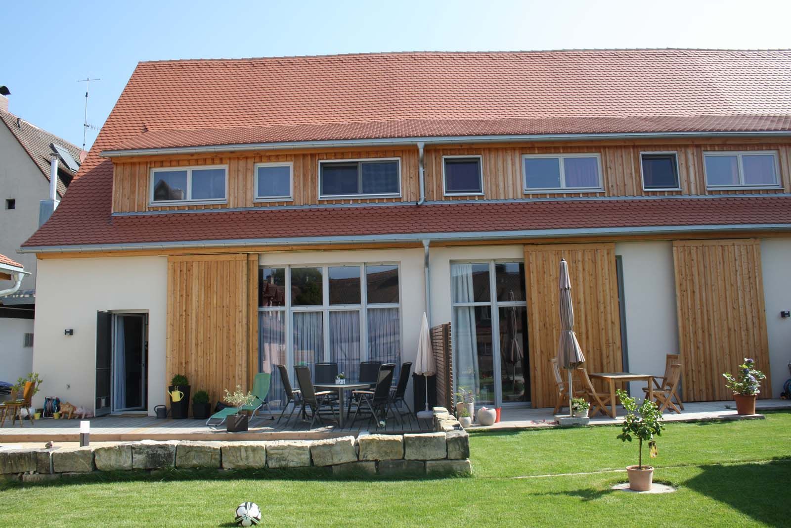 Sanierte Wohneinheit eines denkmalgeschützten Bauernhofs mit Holzelementen, Terrasse und Rasen, Bauwerkstrockenlegung Sven Langer GmbH