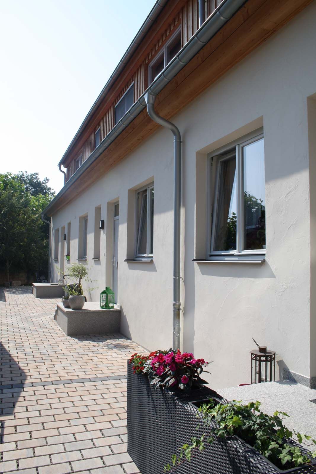 Sanierte Wohneinheit eines denkmalgeschützten Bauernhofs mit Hauseingang und gepflastertem Zugang, Bauwerkstrockenlegung Sven Langer GmbH