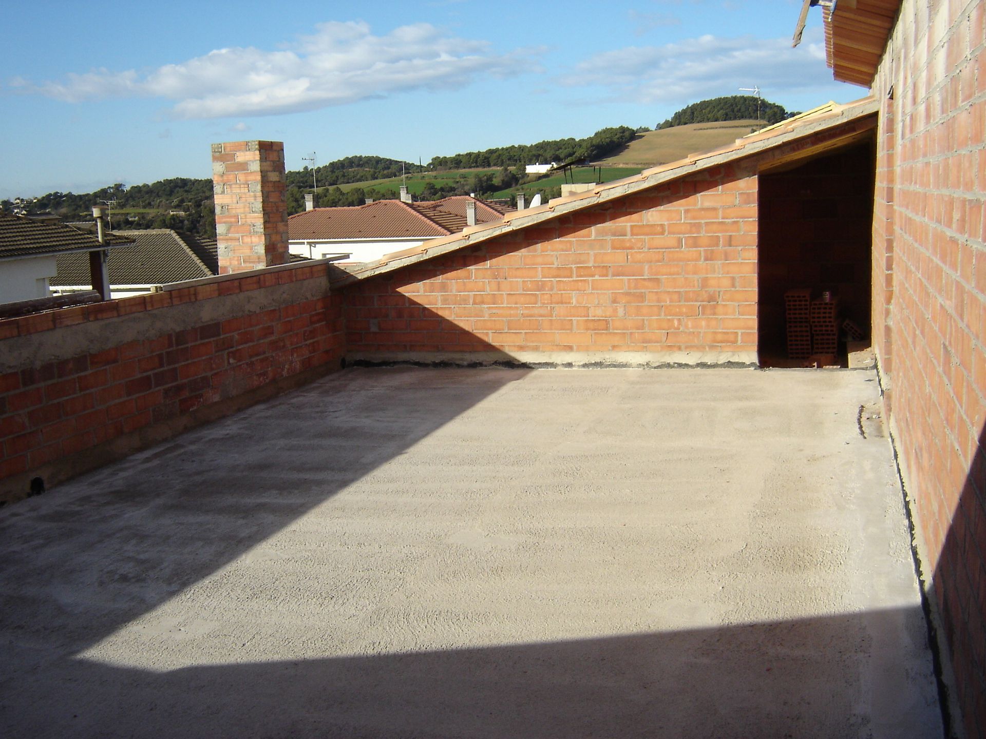 Un edificio de ladrillo con un techo que tiene una chimenea