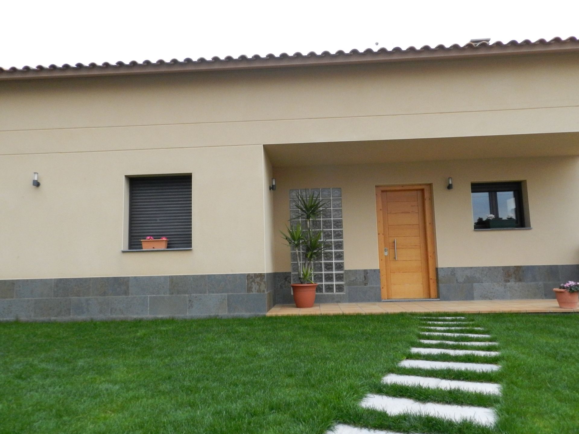 Una casa con una planta en maceta delante de ella