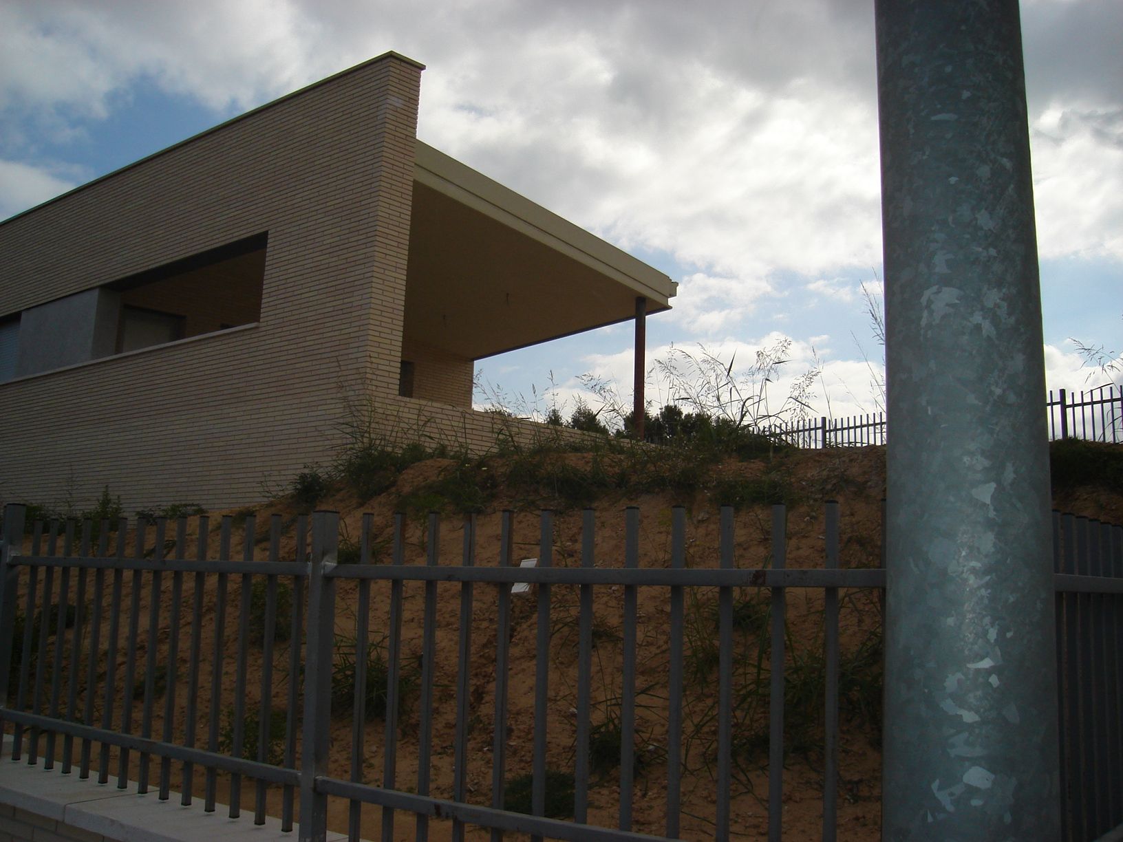Una valla rodea una casa en una ladera