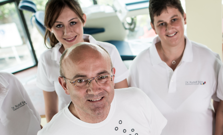 Eine Patientin lächelt, während der Zahnarzt sie in einer Klinik mit Gesichtsmaske untersucht.