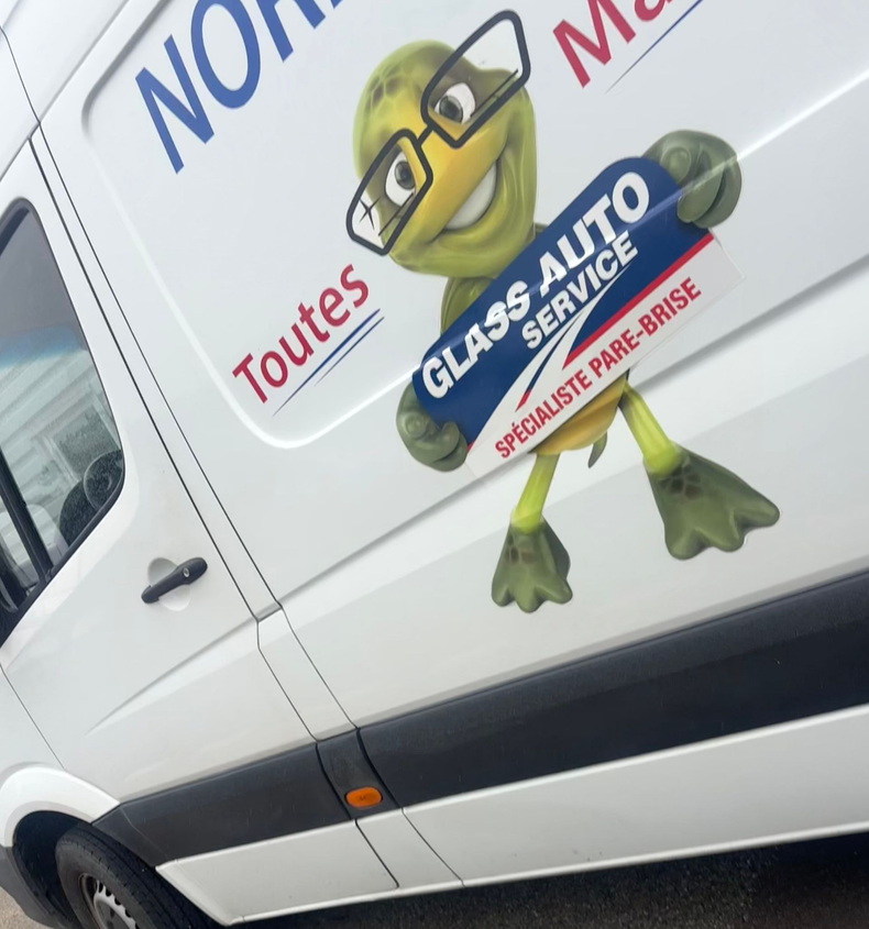 Camionnette avec un logo de grenouille de dessin animé et un texte en français pour une entreprise de services de vitrerie.