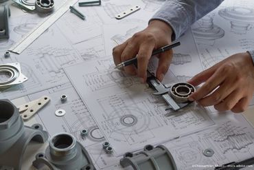 Heinrich Hofmann Maschinenbau GmbH Person nimmt Maß anhand eines Plans