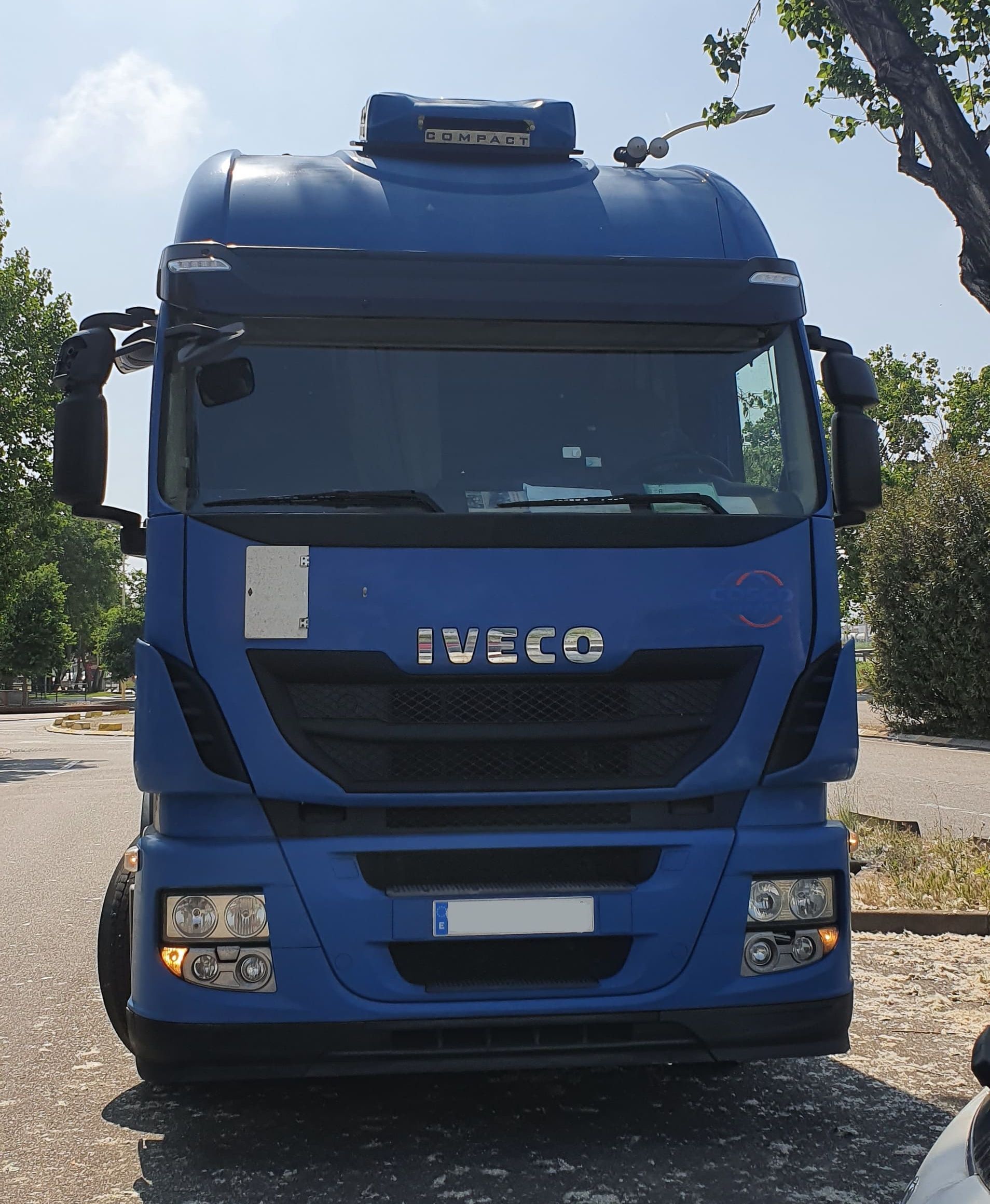 Un camión Iveco azul está estacionado en un estacionamiento.