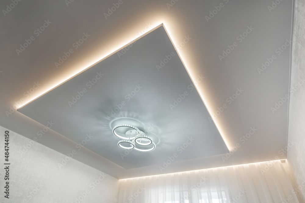 Un plafond moderne doté d'un panneau central rectangulaire flottant.