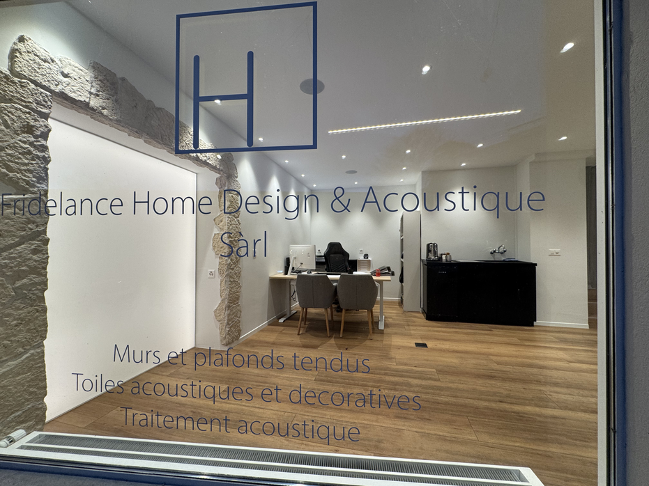 Vitrine avec logo bleu, bureau et parquet dans une salle d'exposition de design et d'acoustique pour la maison