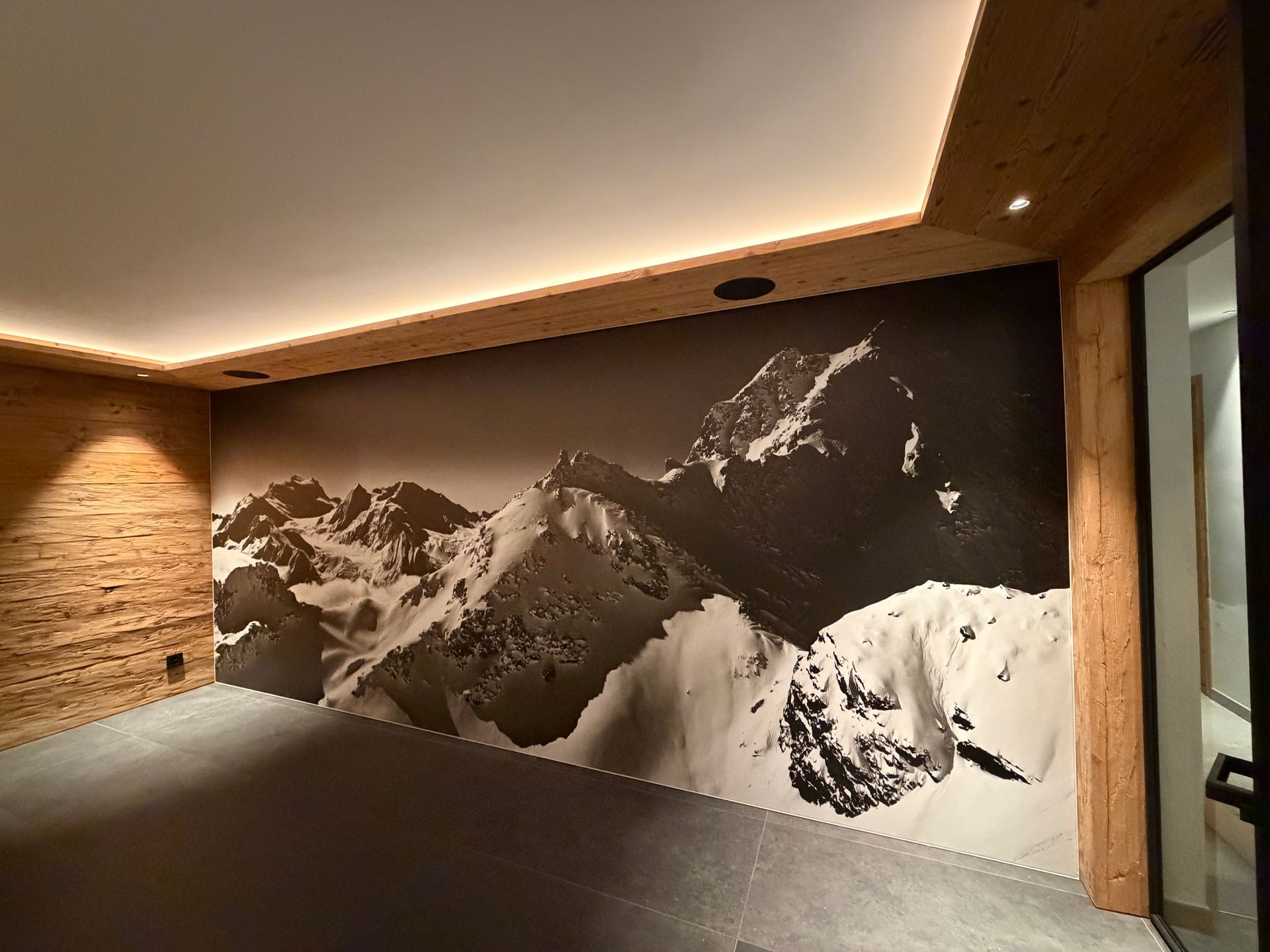 Couloir intérieur moderne avec une grande fresque murale en noir et blanc représentant une montagne.
