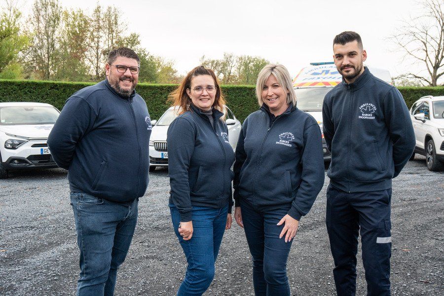 Equipe d'ambulanciers devant la flotte de véhicules