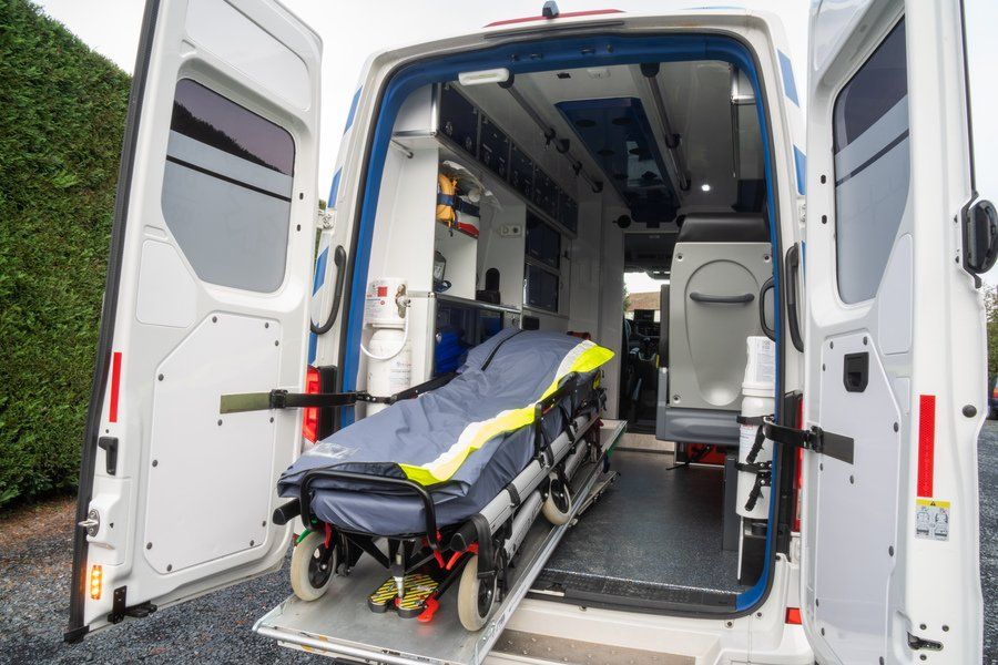 Brancard sur roulette entrant dans une ambulance