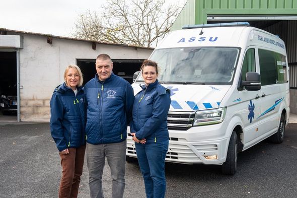 Equipe d'ambulanciers posant devant l'une des ambulances