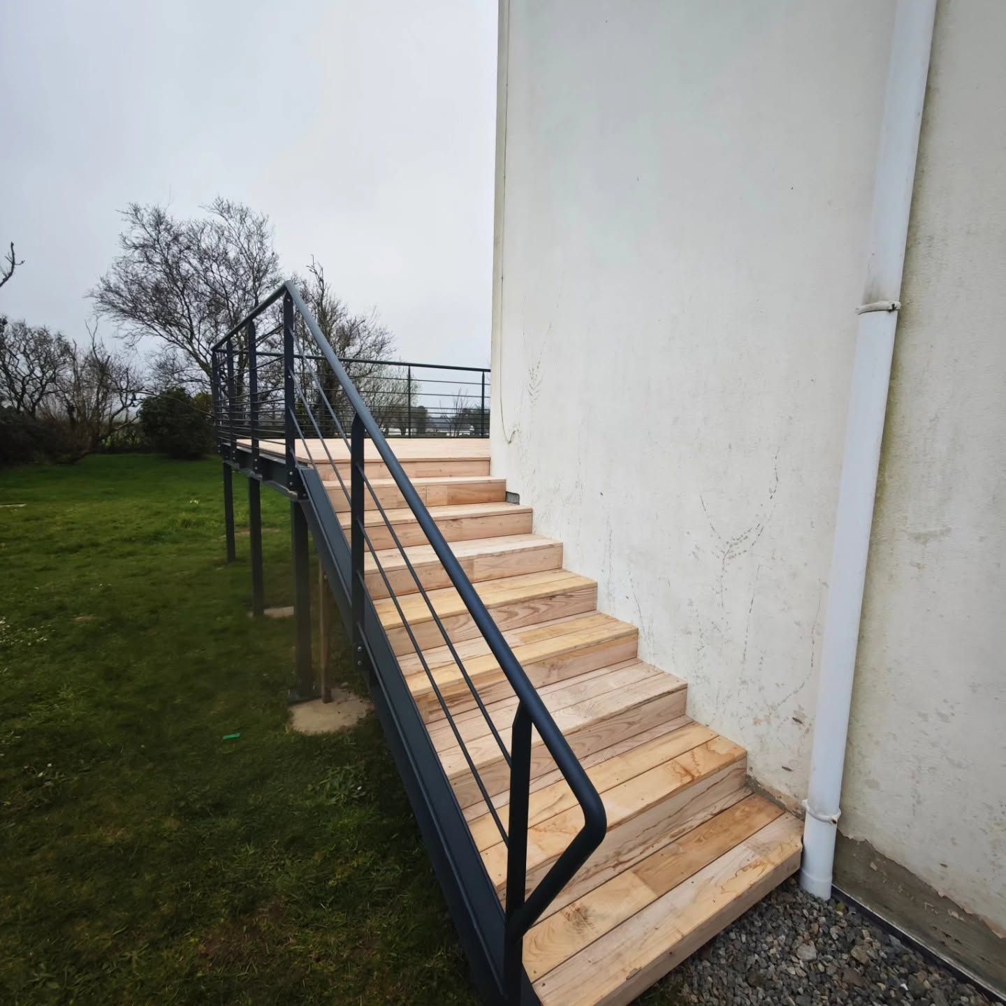 Escalier extérieur en béton avec rampes noires