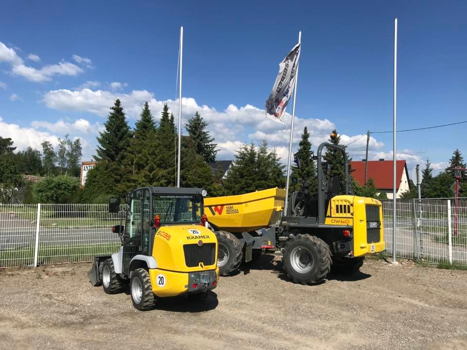 Gelbe Baustellenfahrzeuge parken draußen; sonniger Tag.