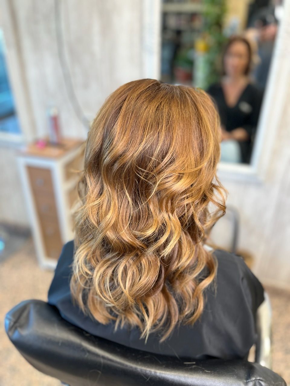 Una mujer está sentada en una silla con su cabello en un salón.