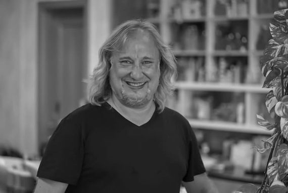 Una mujer con cabello rubio corto tiene un tatuaje en la espalda.