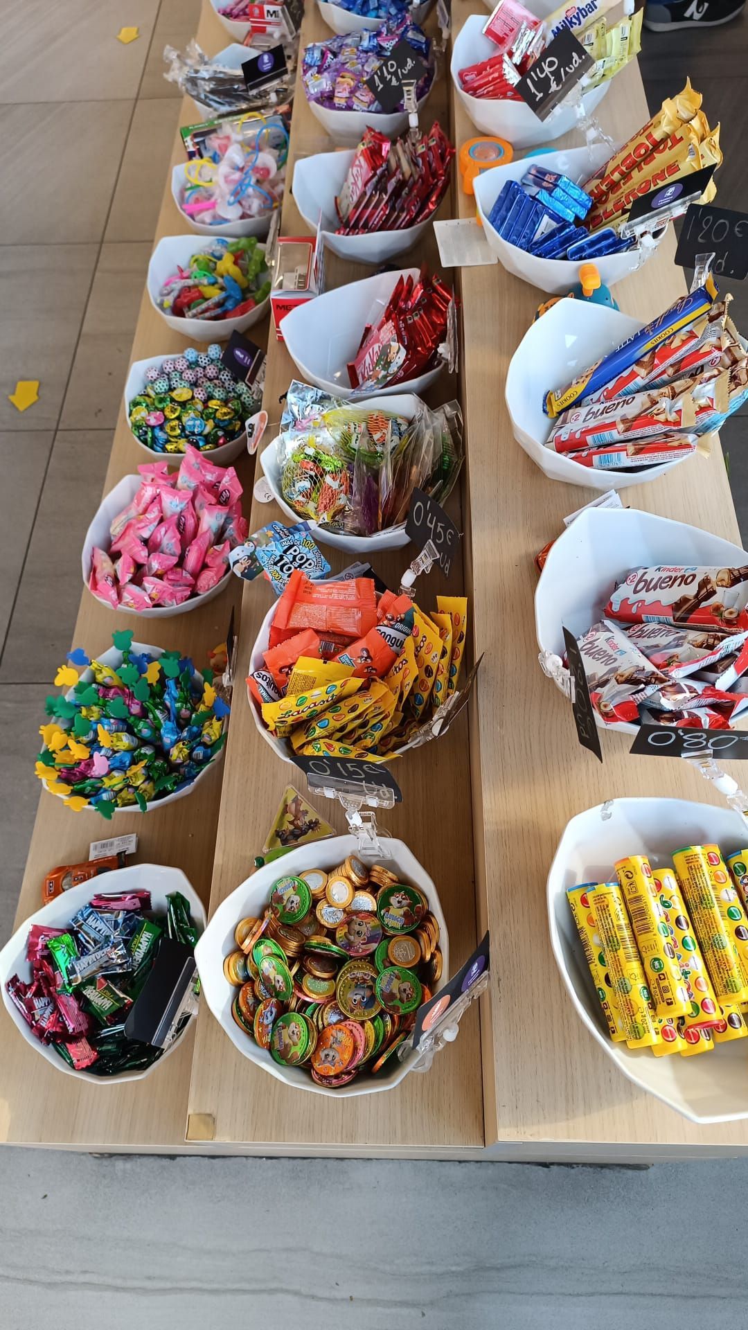 Una mesa cubierta con cuencos llenos de diferentes tipos de dulces.