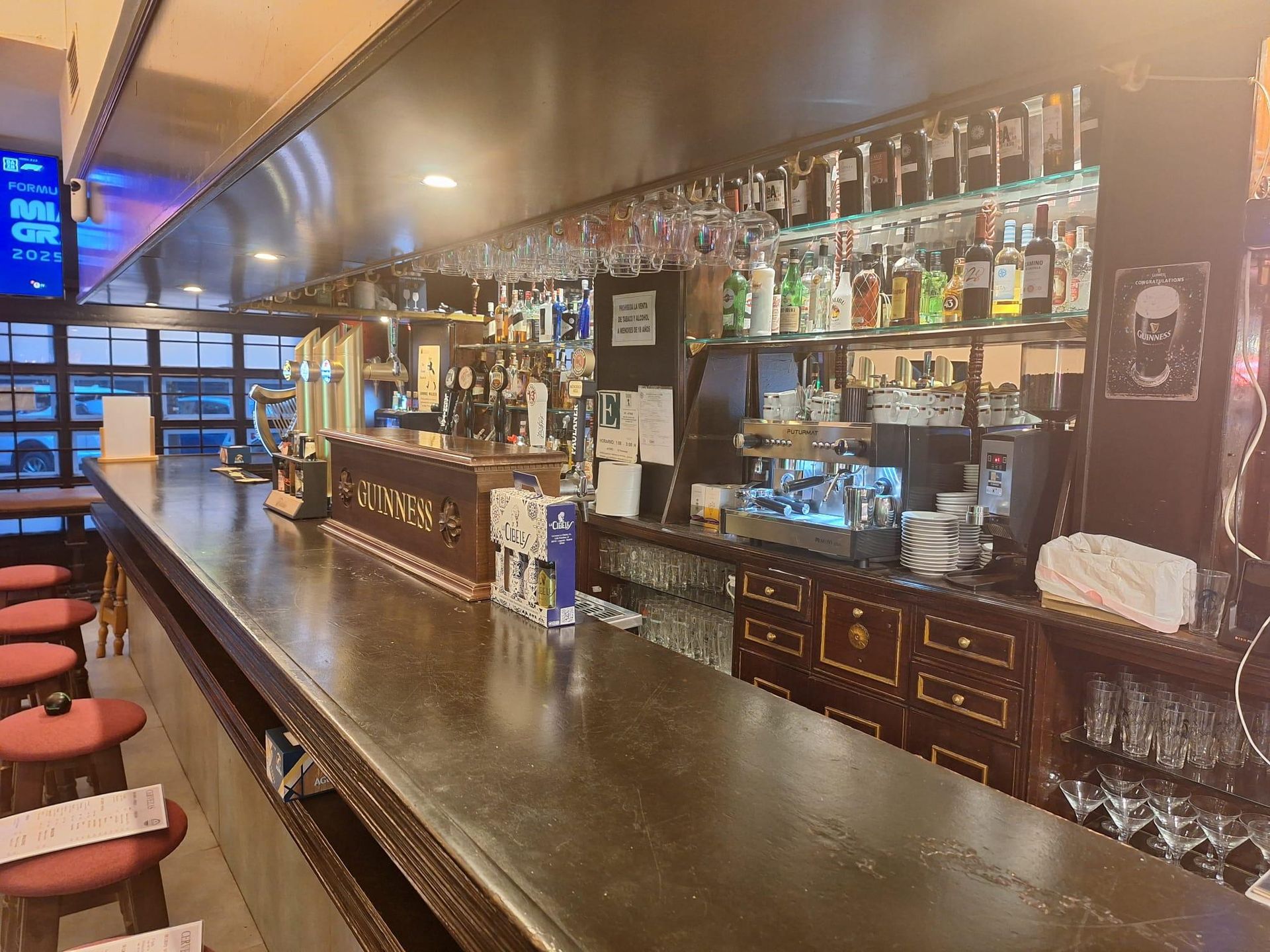 Una barra larga en un restaurante con muchas botellas encima.