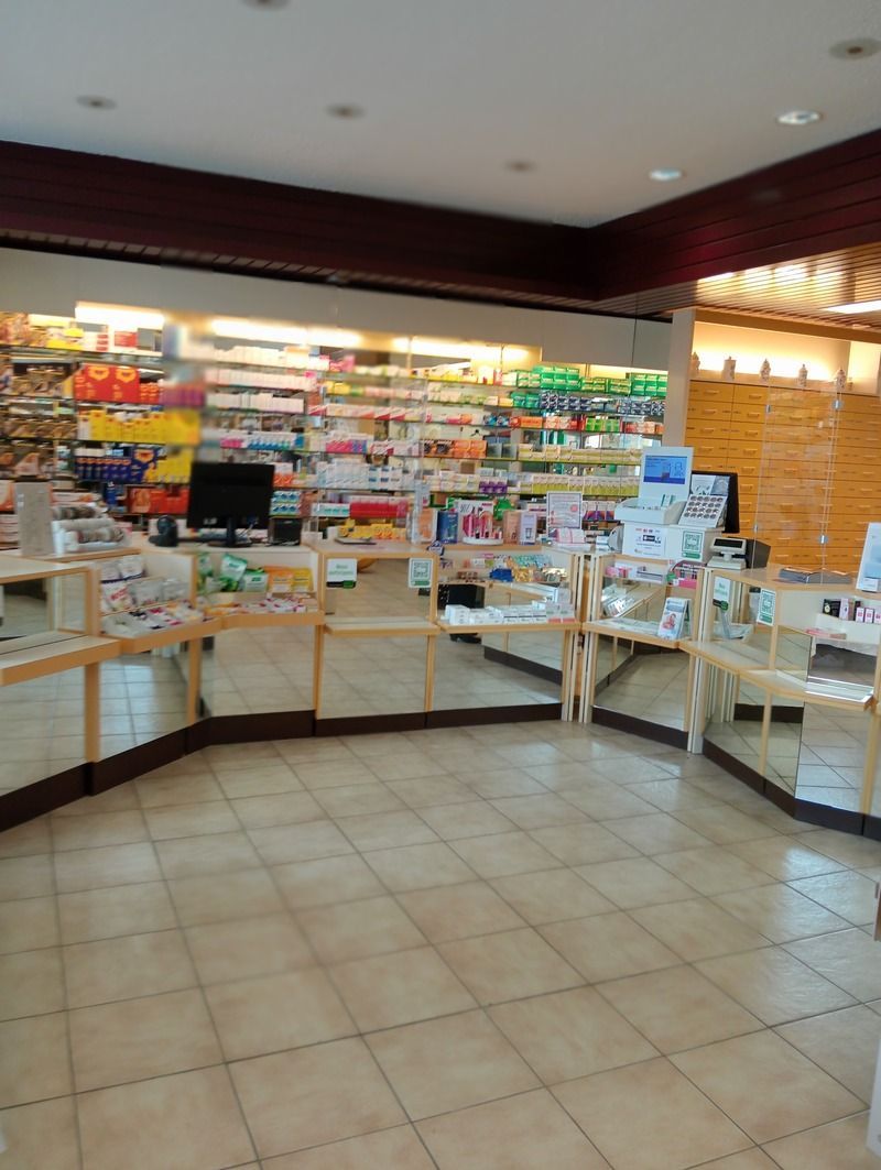 Une pharmacie avec beaucoup d'étagères et un ordinateur sur le comptoir.