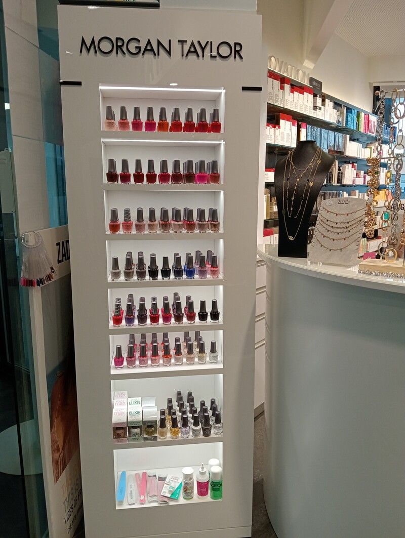 Une exposition de vernis à ongles dans un magasin à côté d'un comptoir.