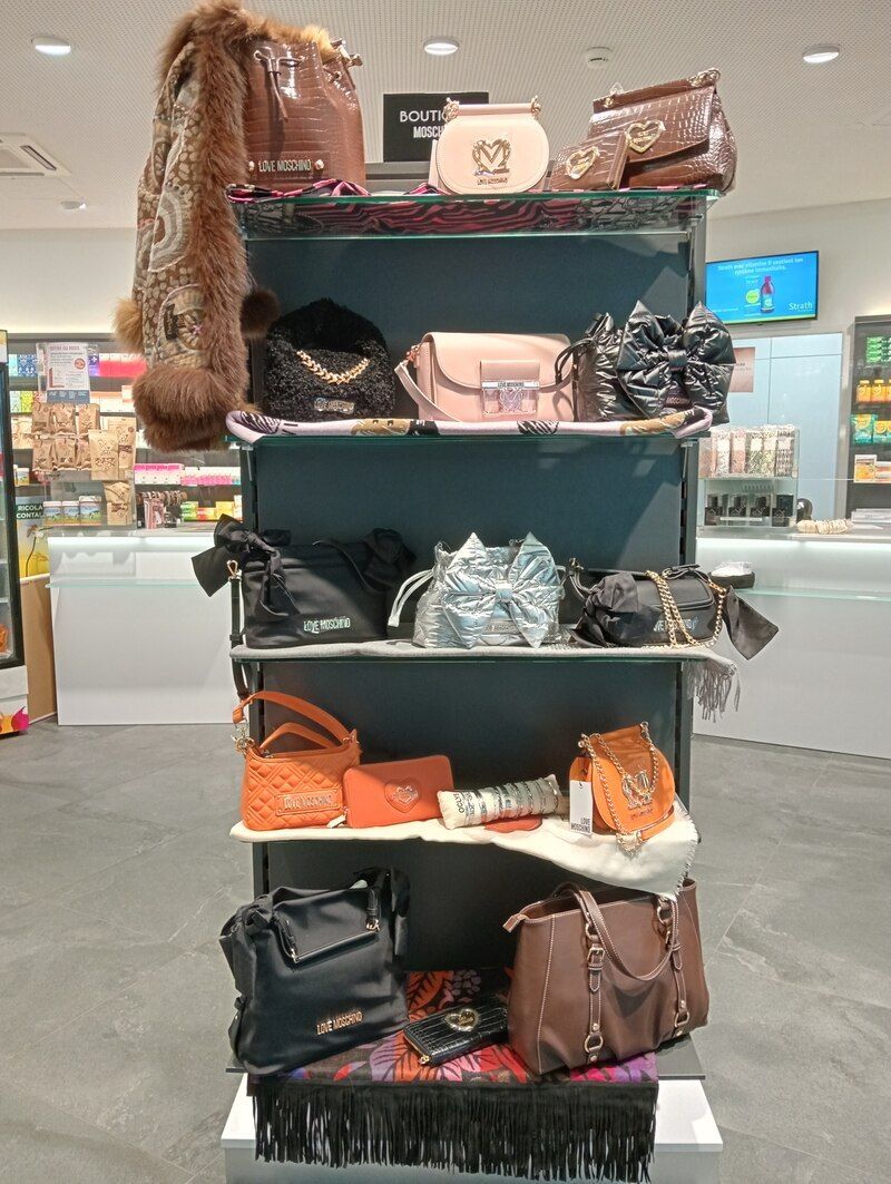 Une exposition de sacs à main sur les étagères d'un magasin.