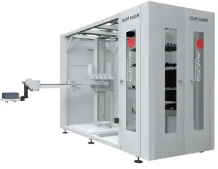 Máquina industrial automatizada con brazo robótico, paneles grises y estantes de almacenamiento.