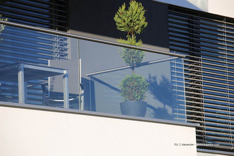 Kind schließt Glasschiebetür der Firma GLAS & SPIEGEL Niederrhein GmbH, die in den Garten führt