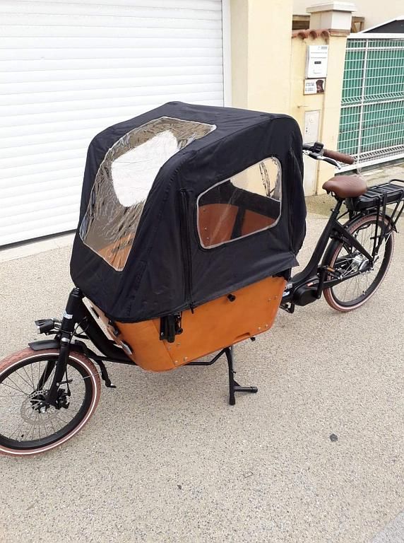 Un vélo avec une assise à l'avant vu de face.