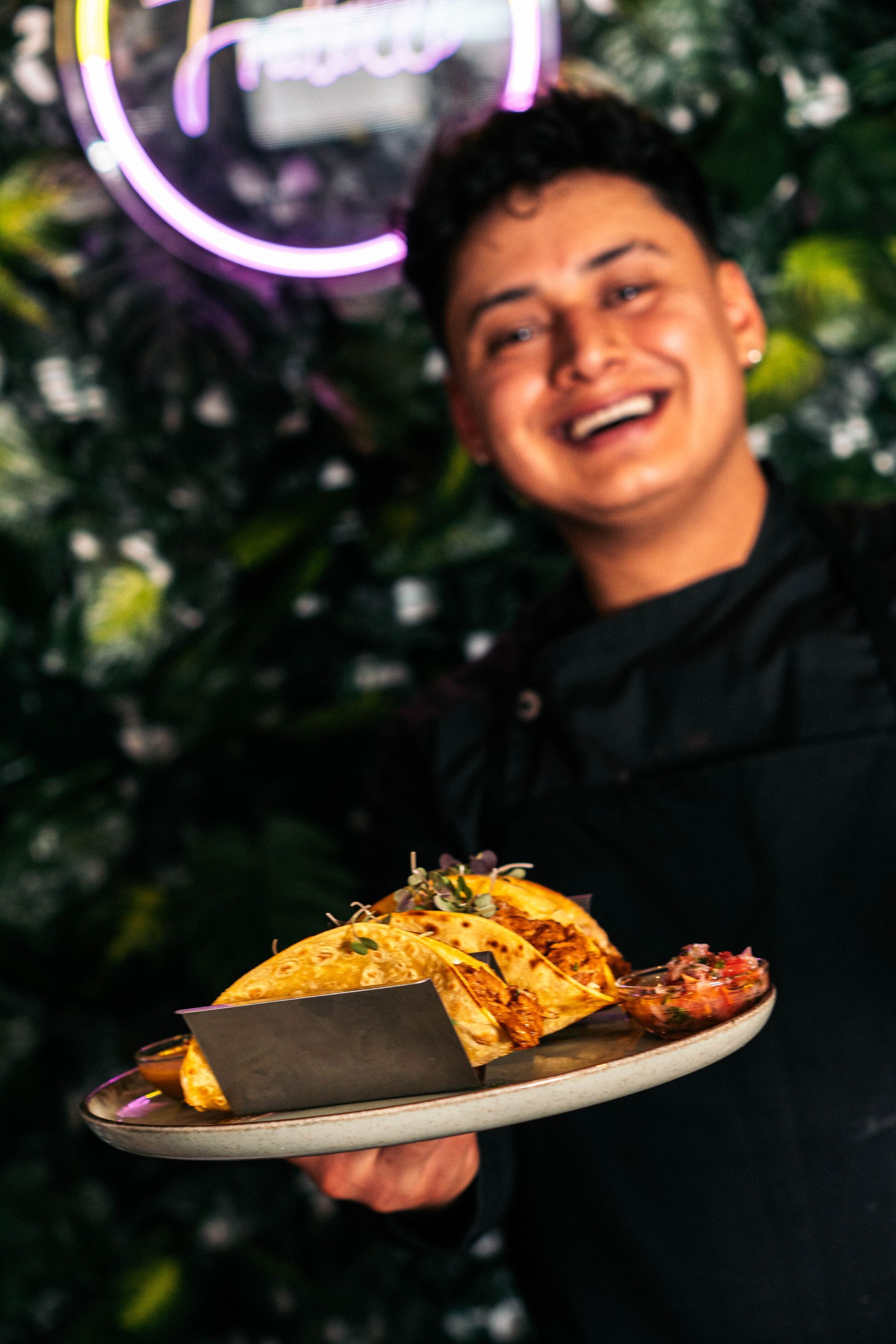 Un hombre sostiene un plato de comida y sonríe.