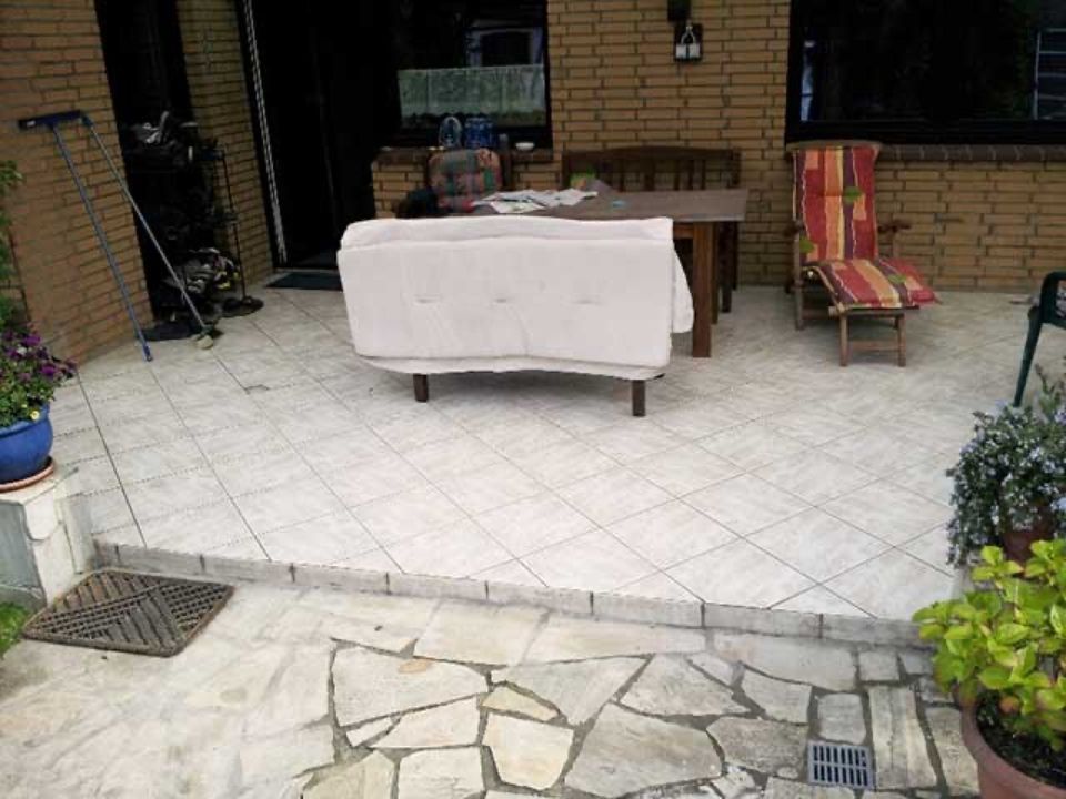 Eine Terrasse mit Sofa, Tisch und Stühlen Scharwat - Fliesen und Naturstein