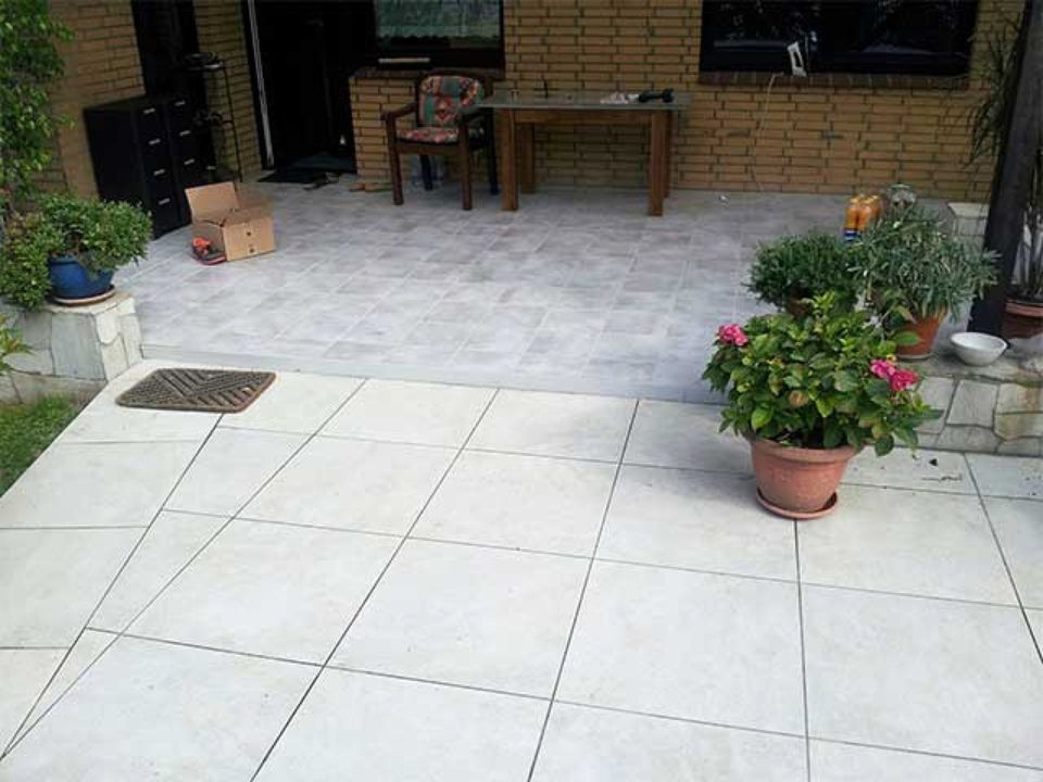 Eine Terrasse mit Tisch und Stühlen und Topfpflanzen Scharwat - Fliesen und Naturstein