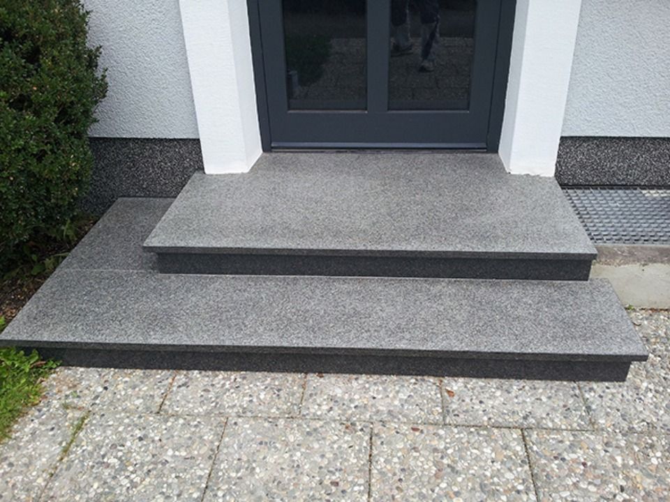 Eine Treppe, die zu einer Gebäudetür hinaufführt.