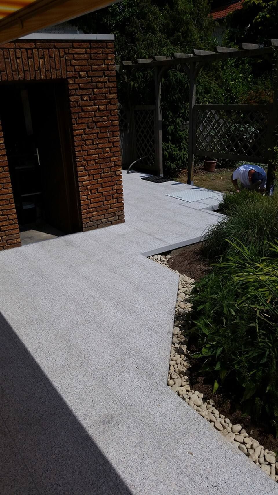 Ein Backsteingebäude mit einem Gehweg davor Scharwat - Fliesen und Naturstein