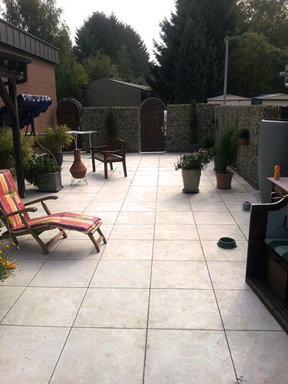 Eine Terrasse mit Stühlen und Topfpflanzen darauf Scharwat - Fliesen und Naturstein