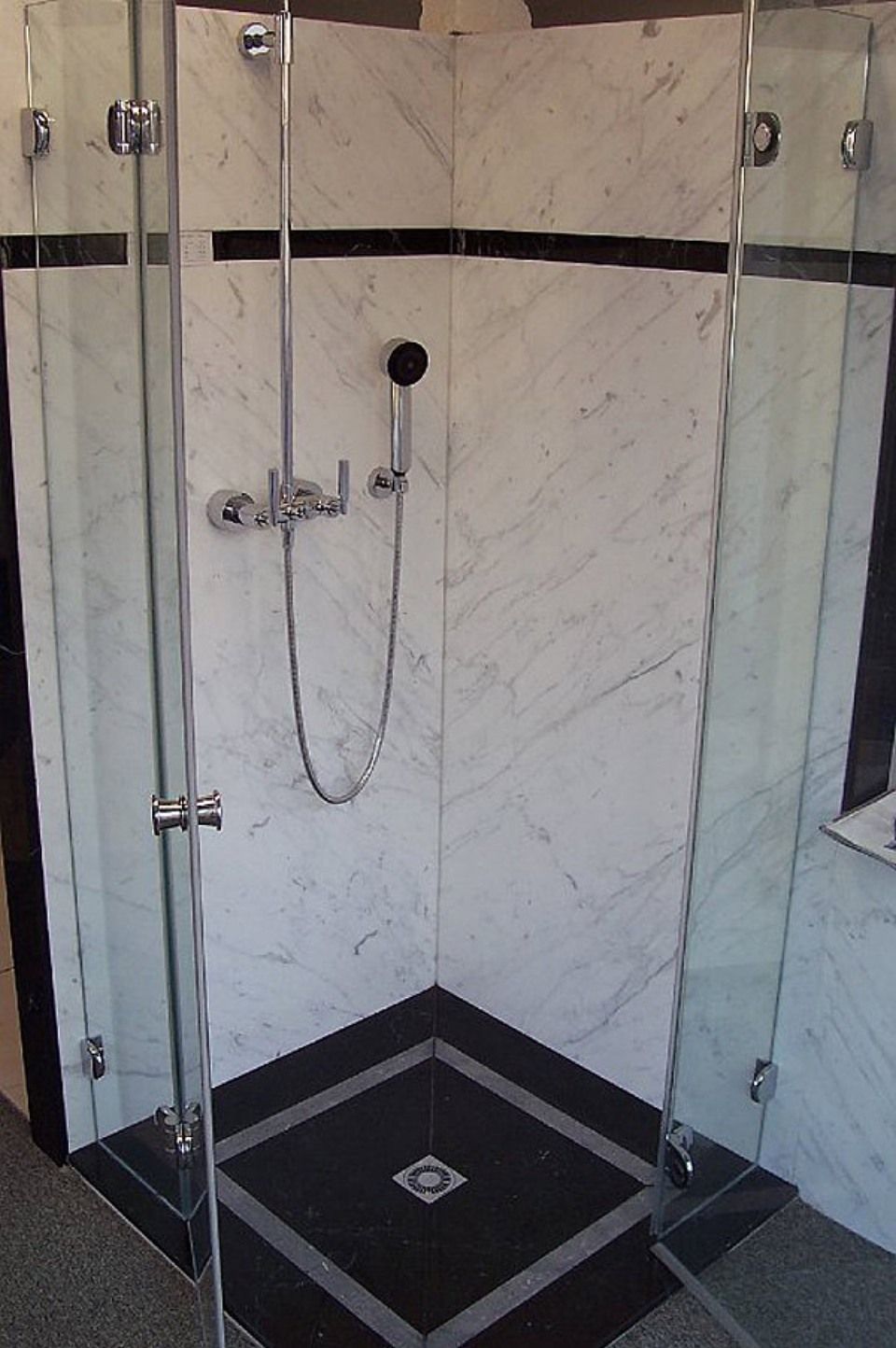 Eine Duschkabine mit schwarz-weißem Fliesenboden, Scharwat - Fliesen und Naturstein